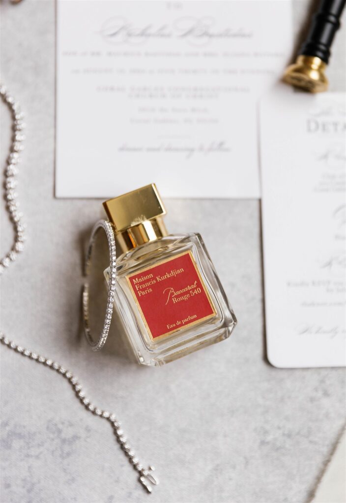 Bridal perfume and wedding invitation detail