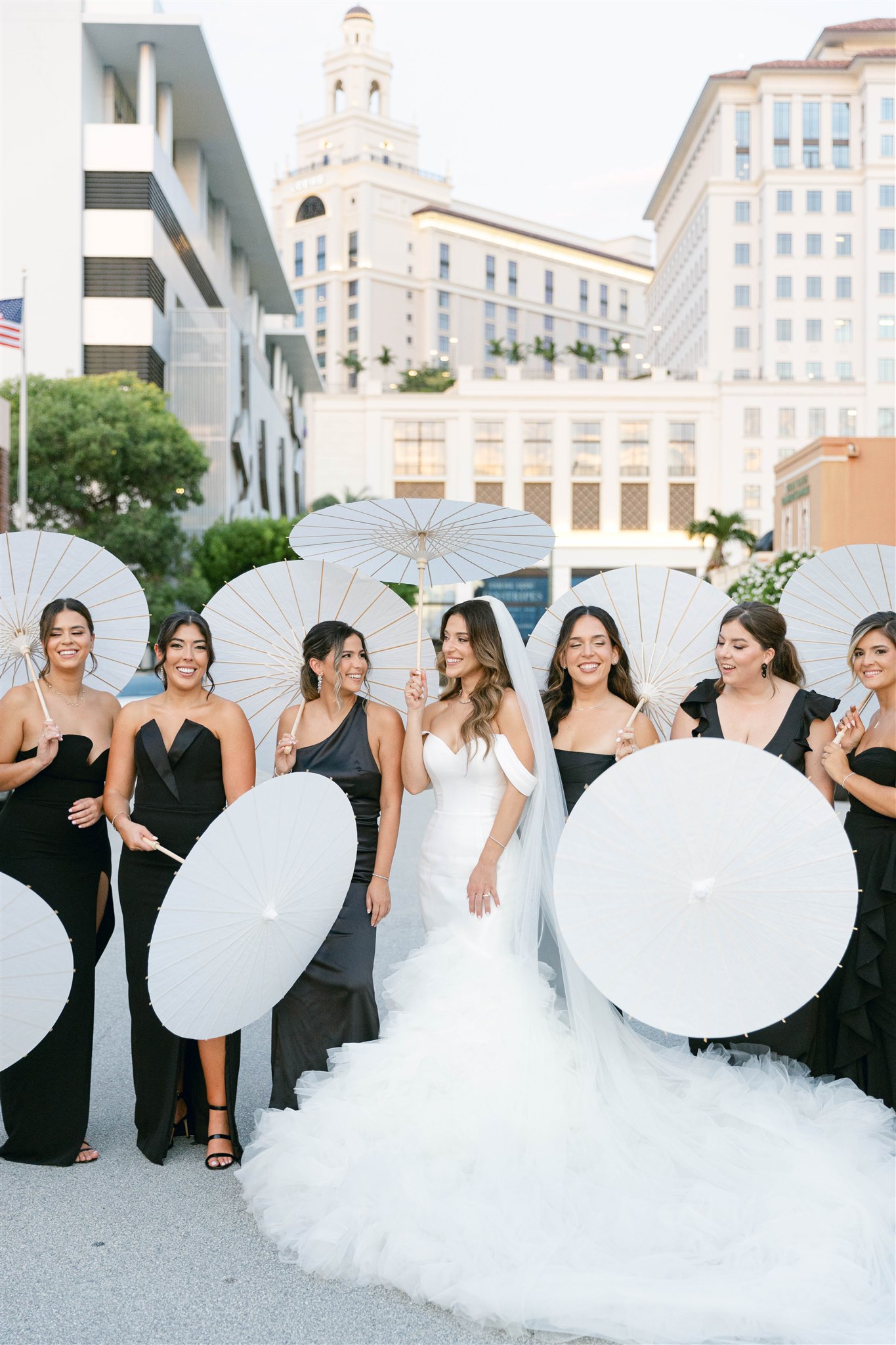 Bride with her bridesmaids holding white parasols in Coral Gables