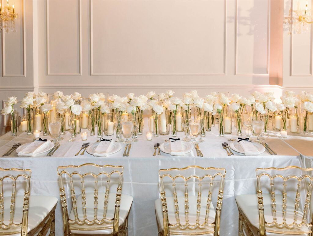 Long reception tables lined with white roses and candles by Amara Rose Events