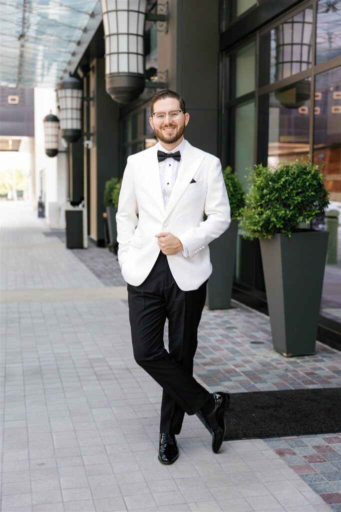 Groom walking in his white tuxedo jacket in Coral Gables