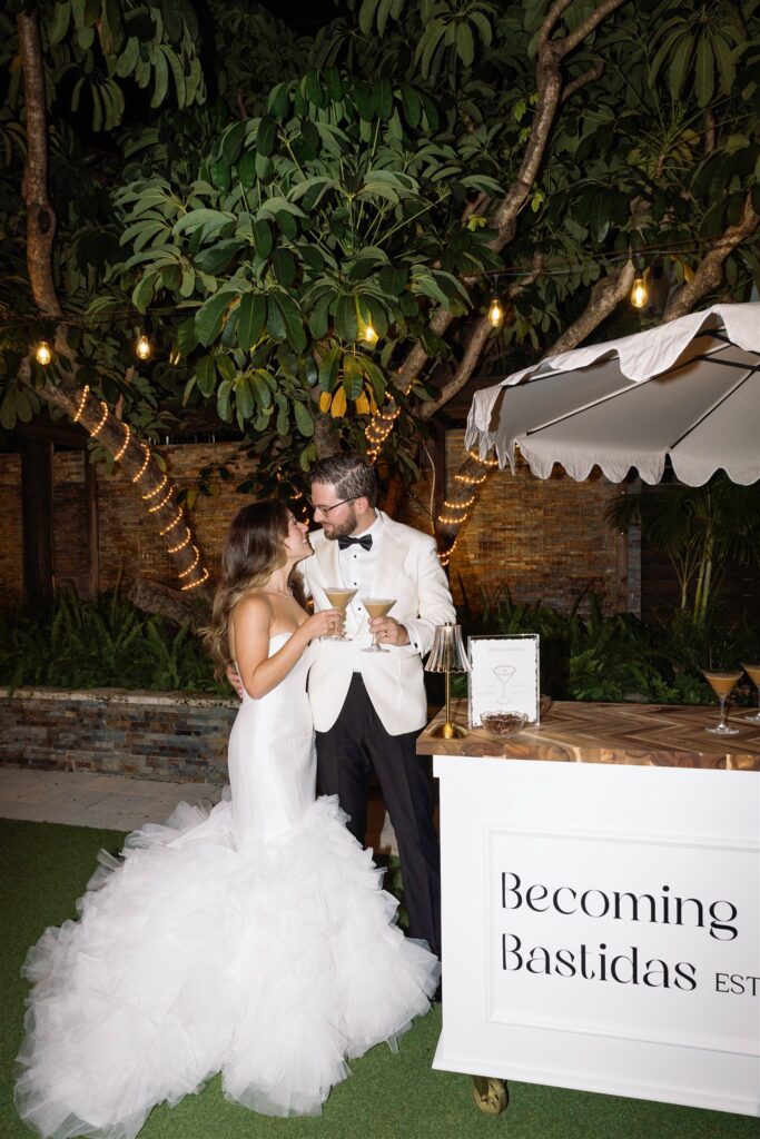 Bride and groom in the garden beside their welcome sign