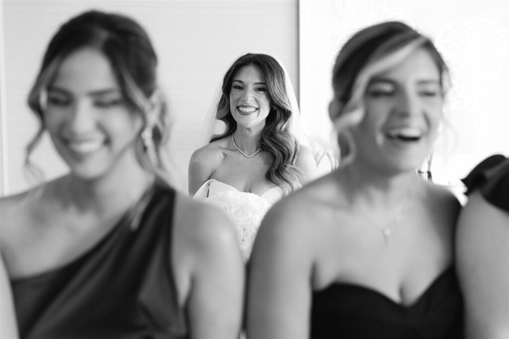 Bridesmaids reacting as they see the bride in her gown