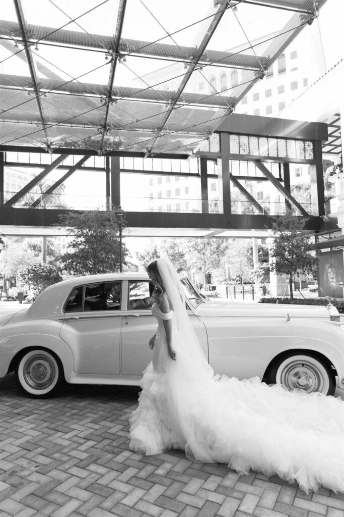 Bride stepping out of a vintage white Rolls-Royce
