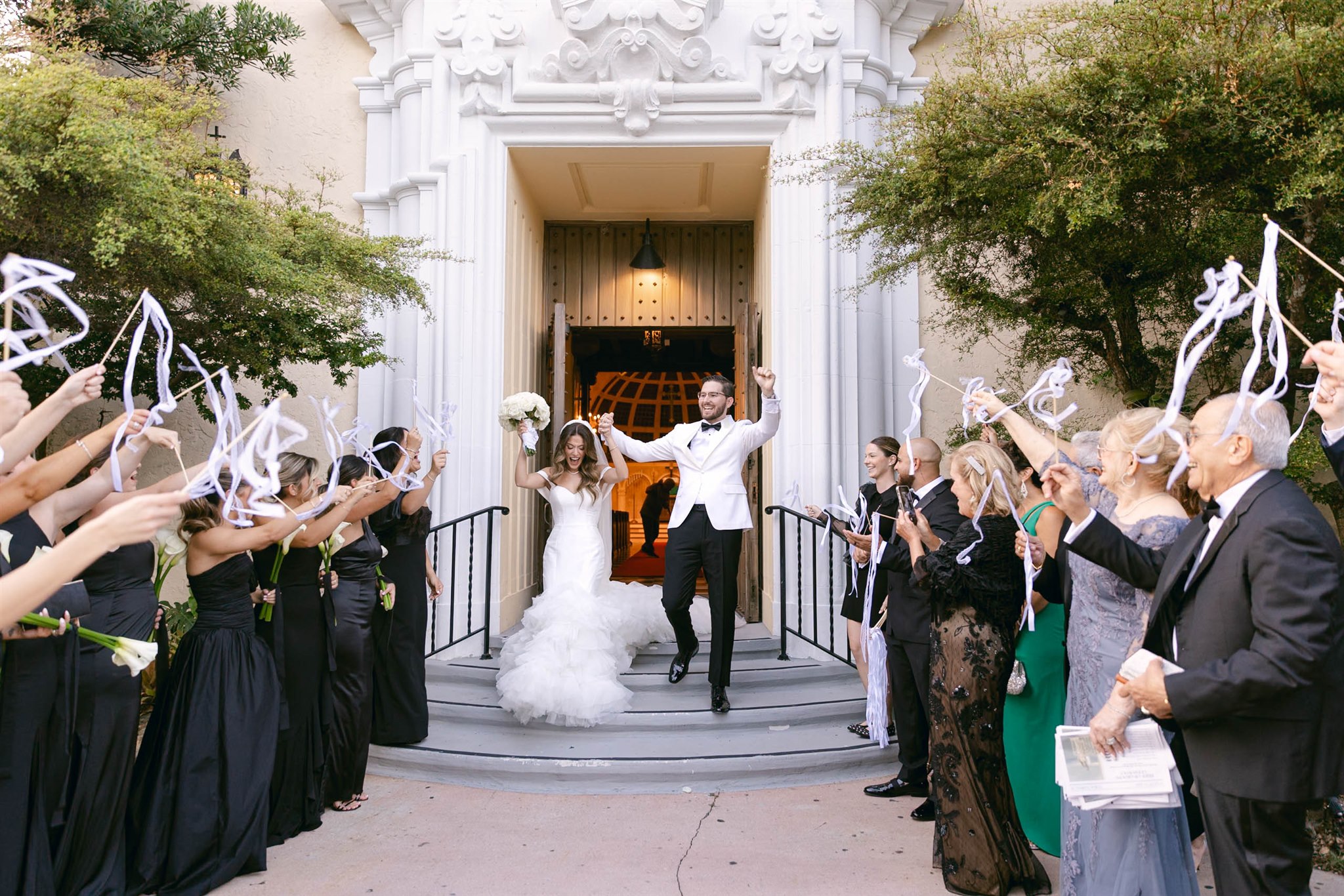 Guests cheering as the newlyweds exit the church