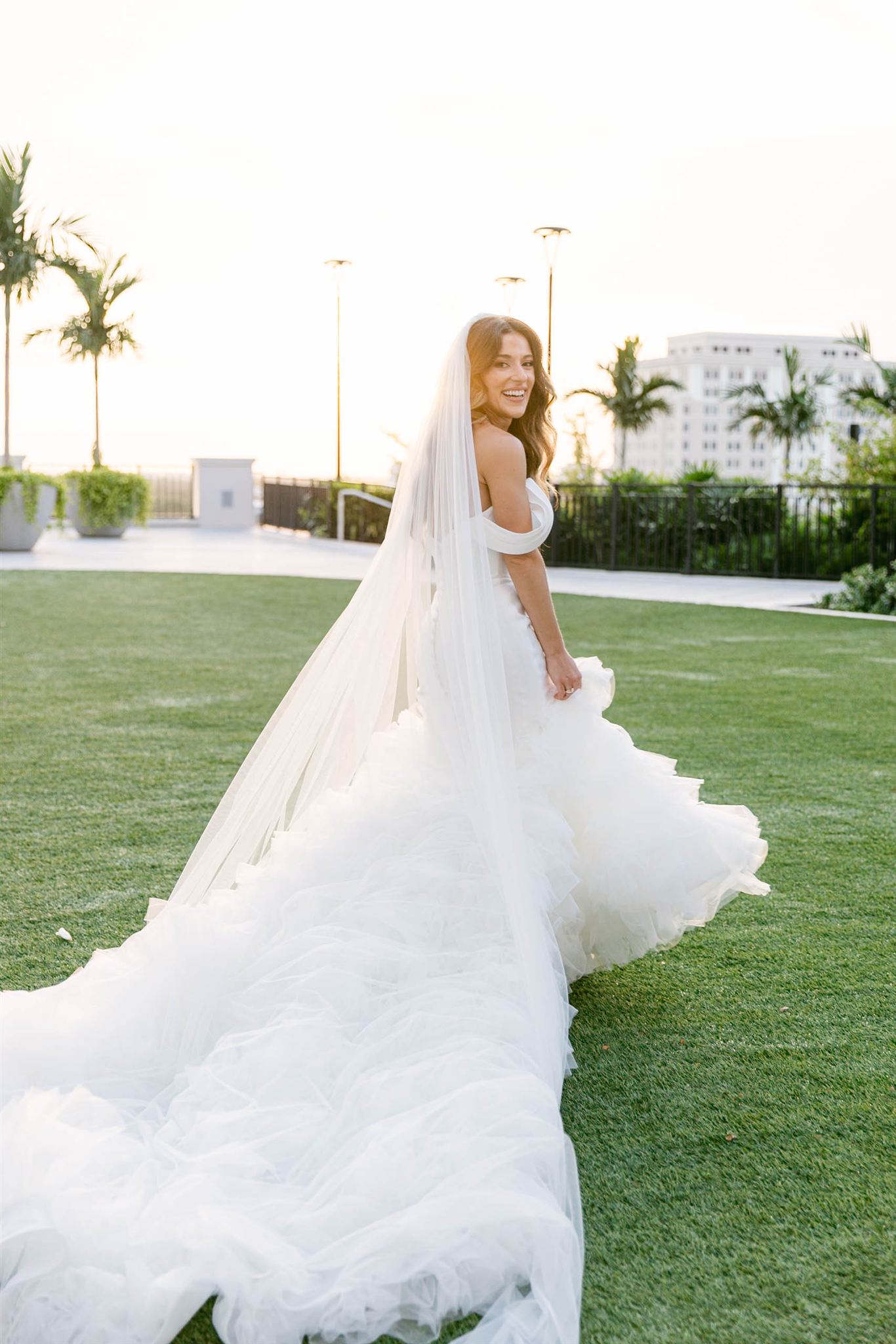 Bride in her mermaid gown walking across the lawn at Loews Coral Gables