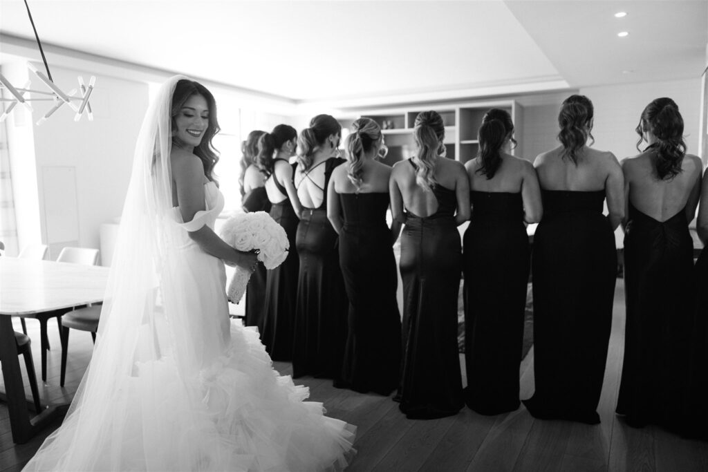 Bride's first look with her bridesmaids in black gowns