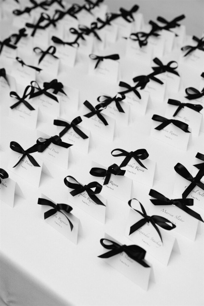 Escort cards tied with black ribbon bows