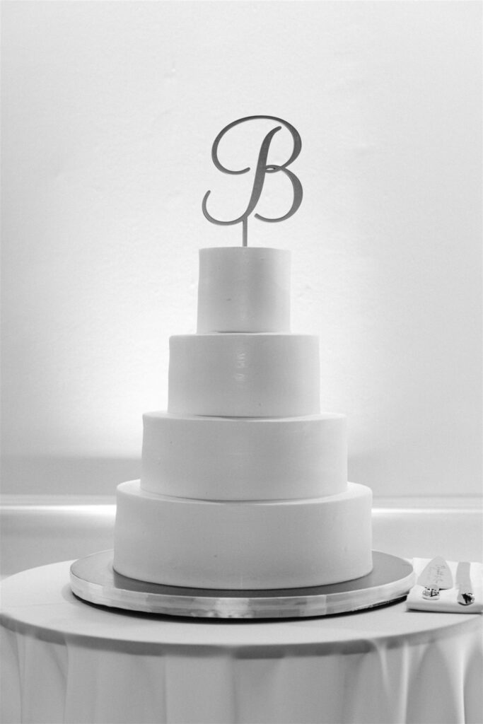 Four-tier white wedding cake with a B monogram by Edda's Cake Designs