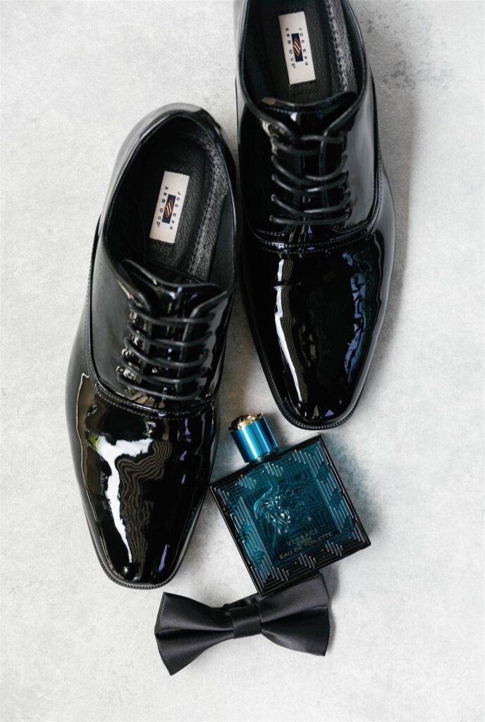 Groom's patent leather shoes, bow tie and cologne