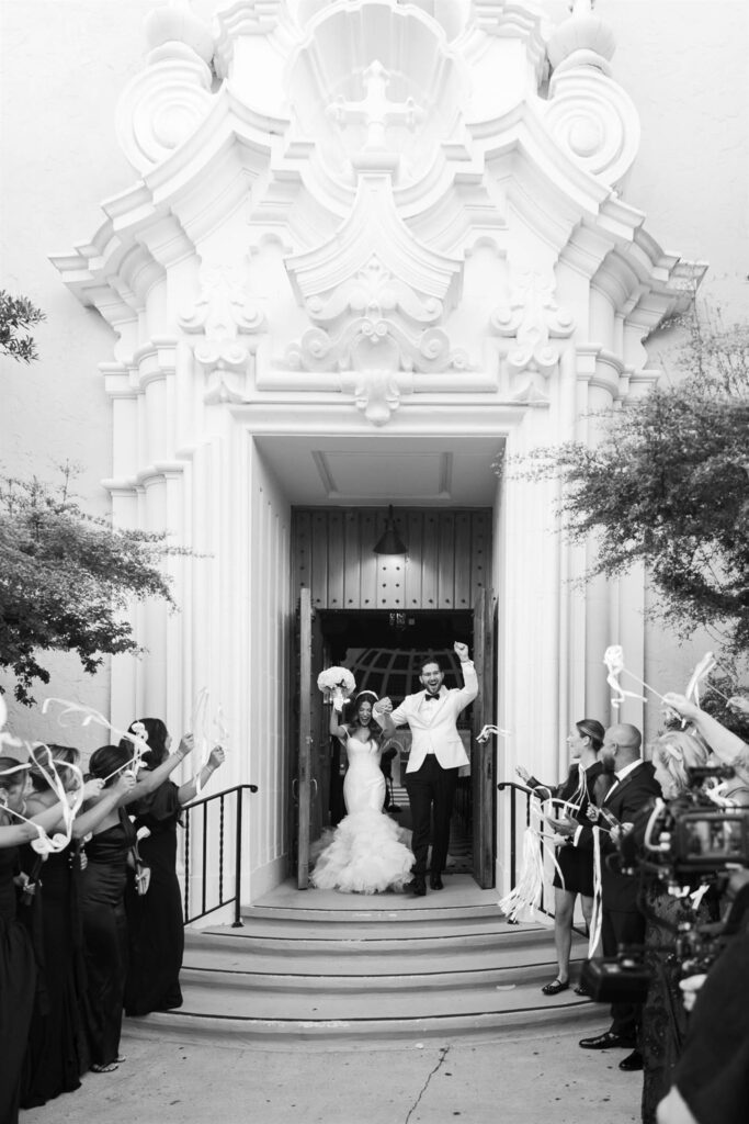 Elizabeth and Nicholas exiting the Coral Gables Congregational Church as guests cheer