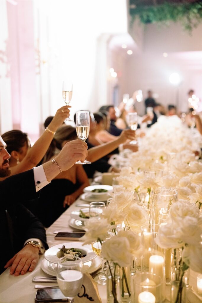 Guests at long candlelit reception tables