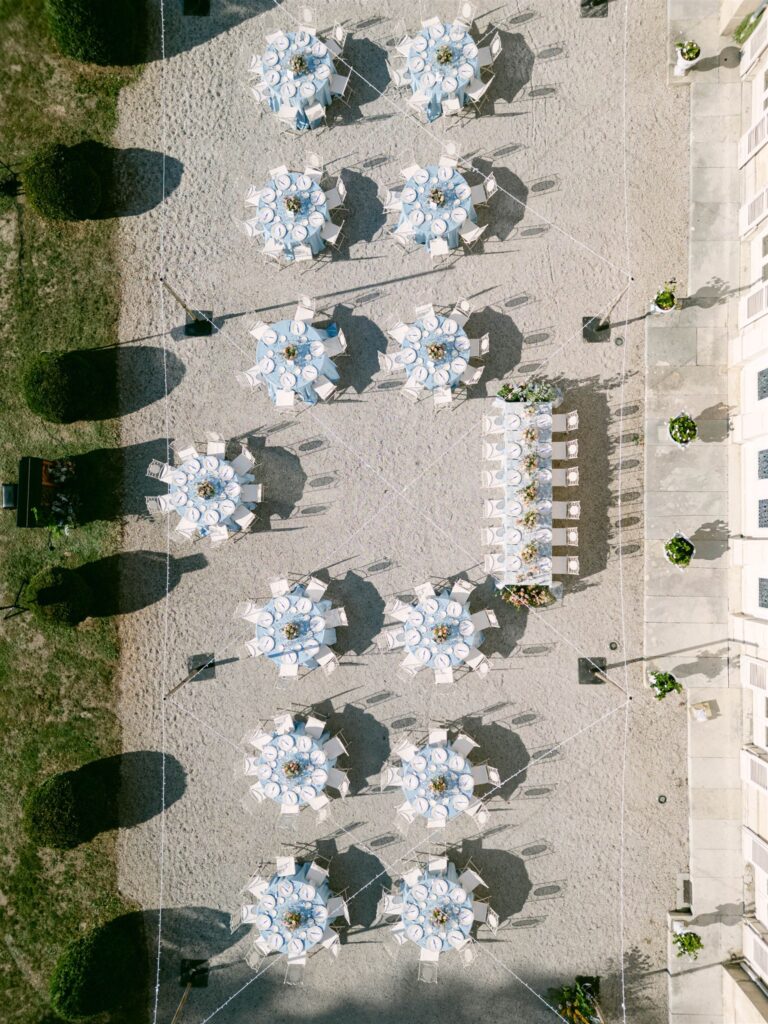 Aerial view of round reception tables laid out in front of the château