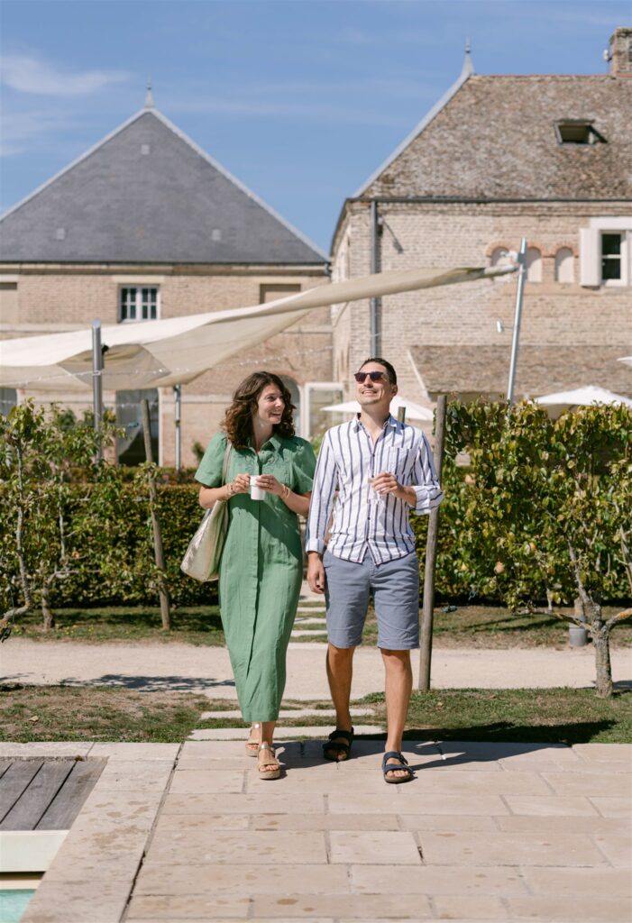 Two guests walking arm in arm toward brunch in front of the château