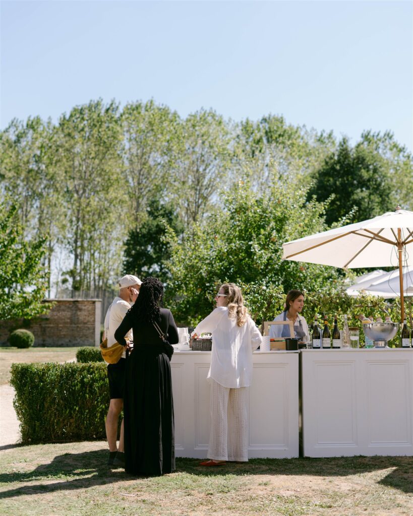 Brunch buffet bar set up beneath white umbrellas on the lawn