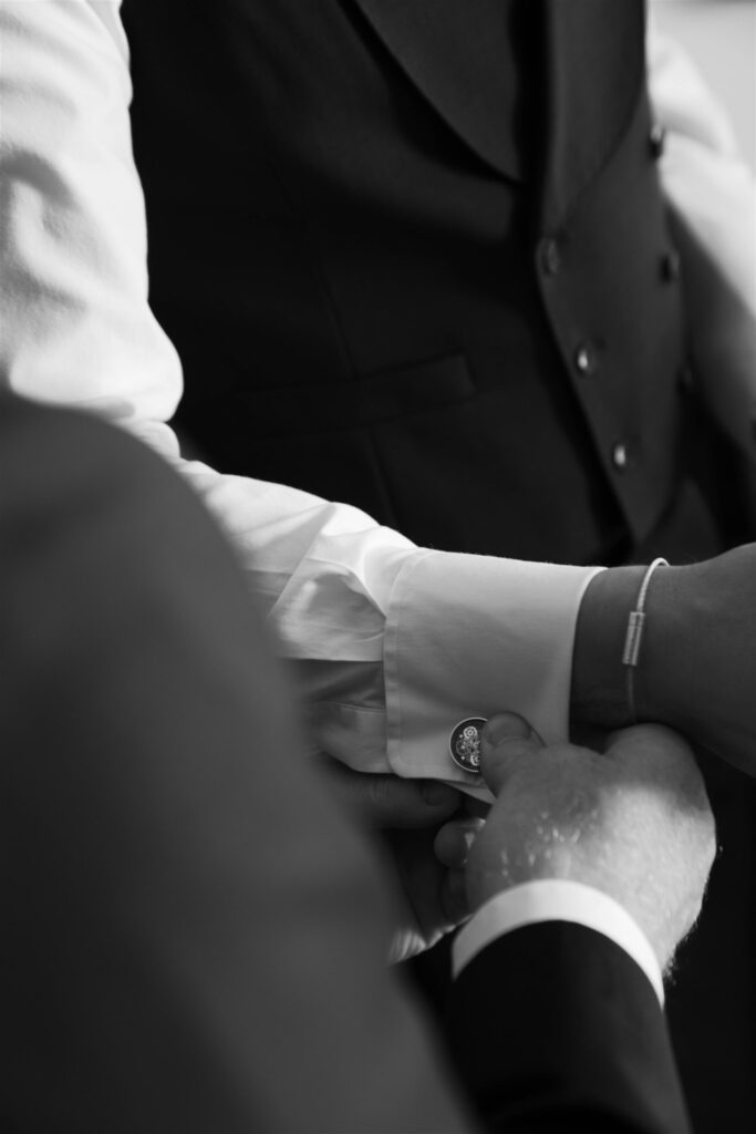 Black and white detail of Jonathan's suit sleeve and cuff while getting ready