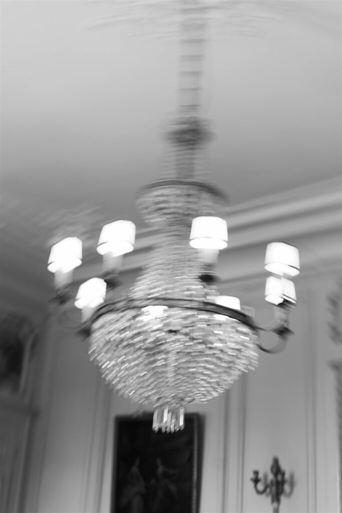Black and white photo of a crystal chandelier inside Château de Varennes
