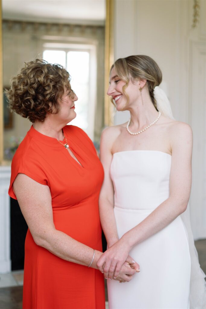 Romy holding hands and smiling with a woman in an orange dress