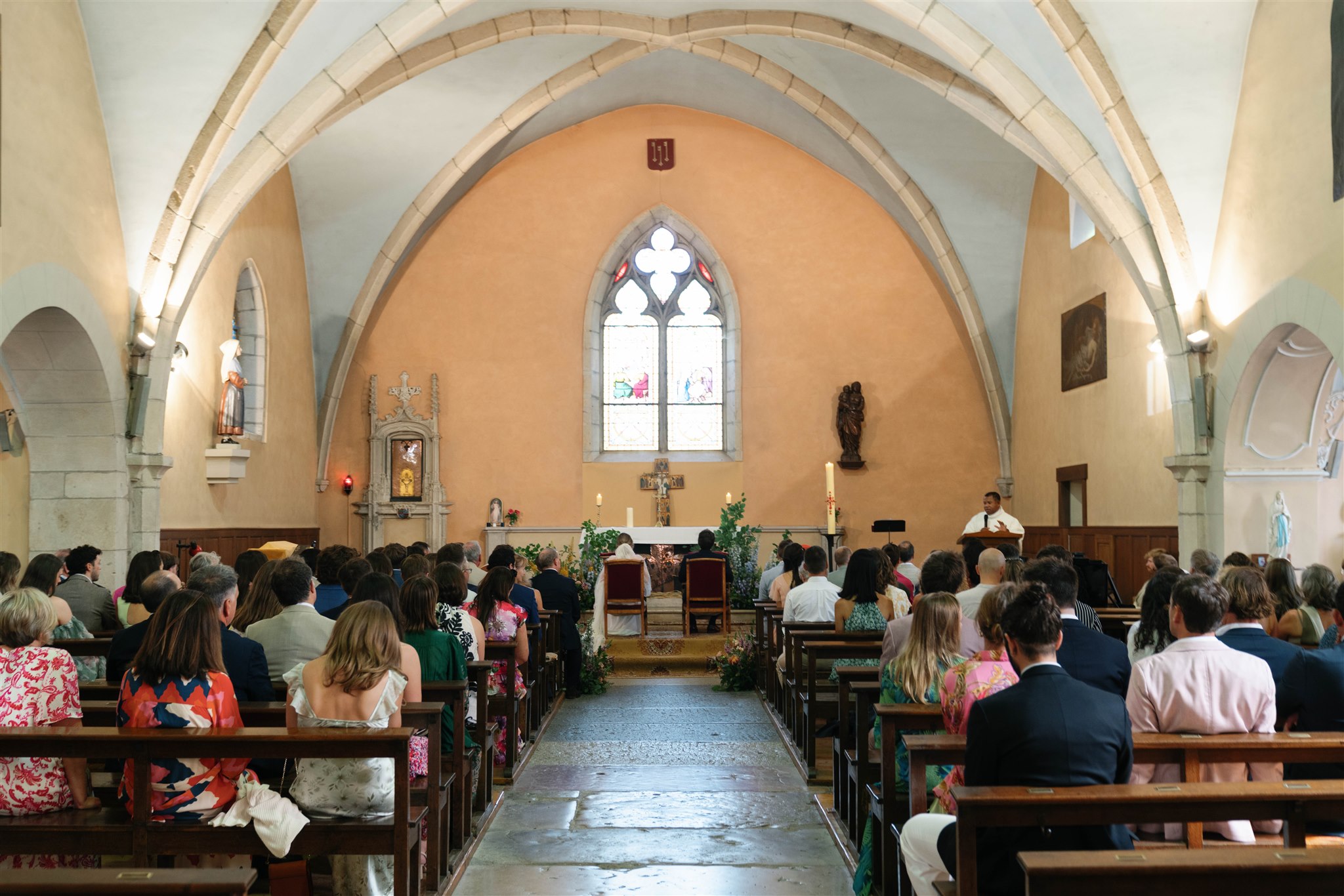 Wide view of the small church interior with guests seated beneath the vaulted ceiling