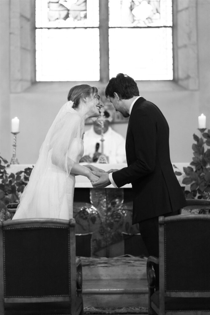 Black and white photo of Romy and Jonathan exchanging vows at the altar