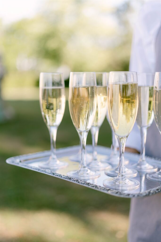Tray of Champagne flutes being served during cocktail hour