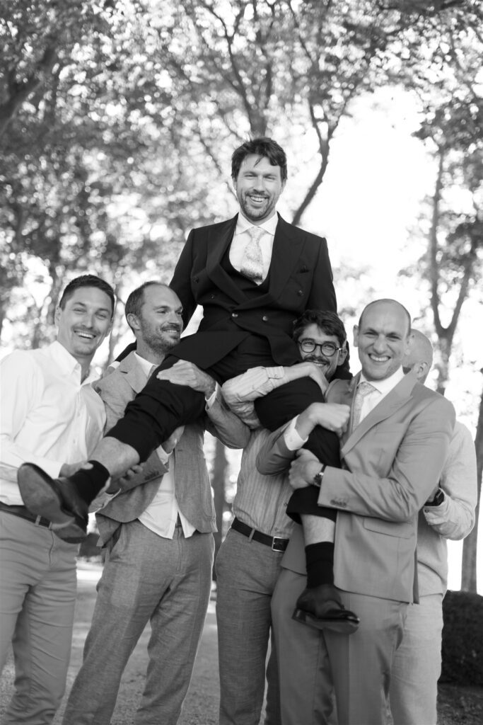 Black and white photo of guests lifting Jonathan into the air in celebration