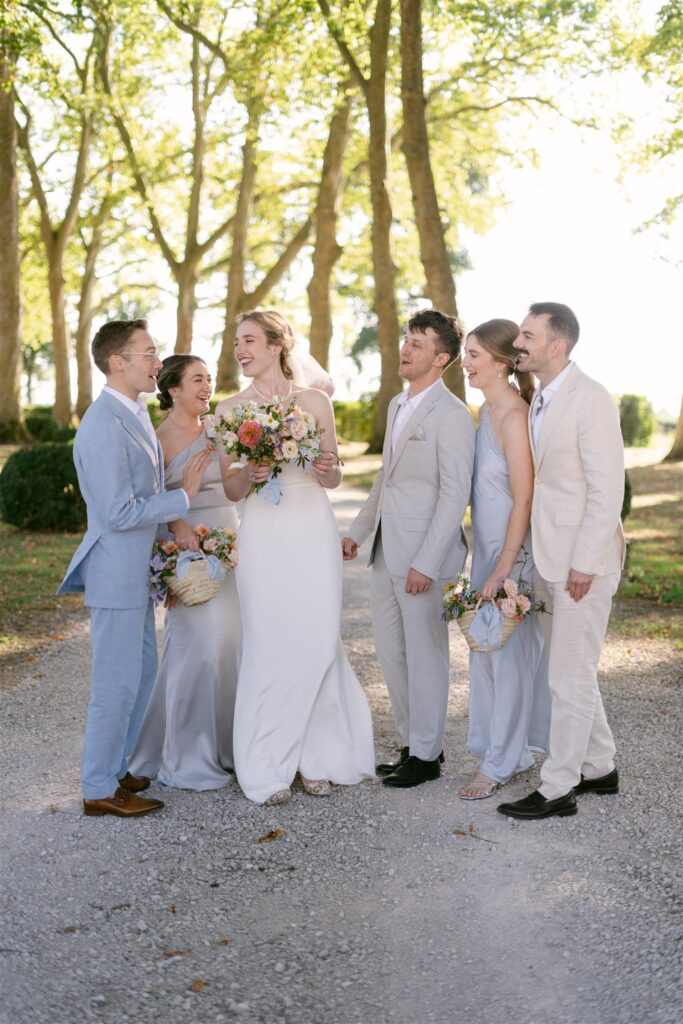 Romy and Jonathan with their wedding party in soft blue standing on the path