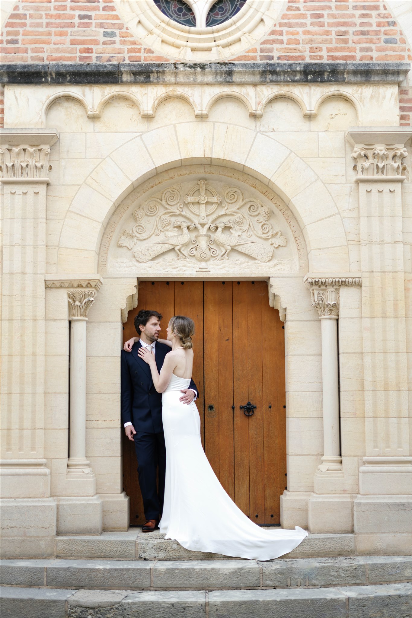 Romy and Jonathan standing in front of the church's carved stone doorway