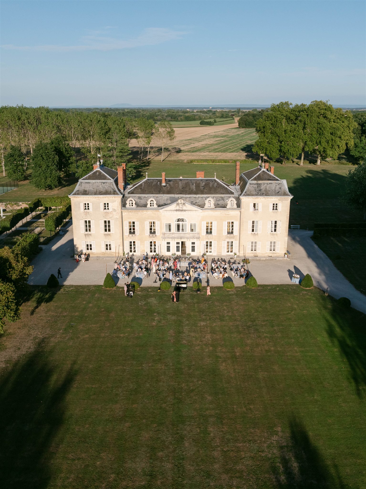 Aerial view of Château de Varennes at golden hour with the reception set on the lawn