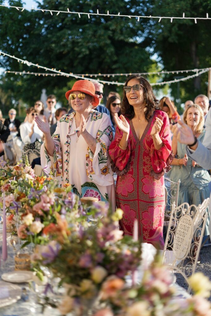 Guests clapping and cheering among flower-filled tables