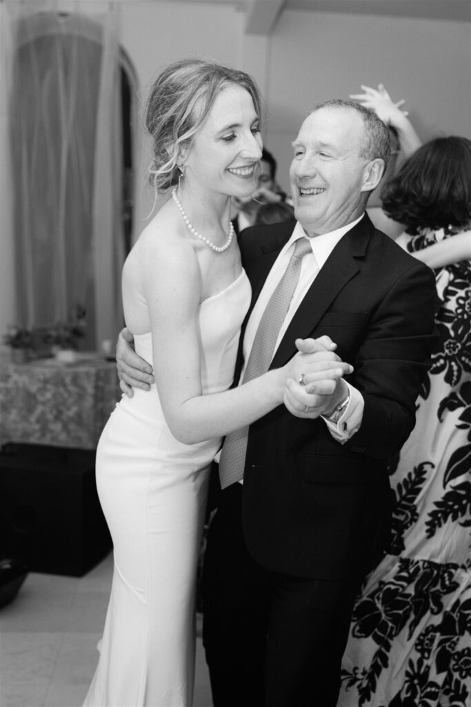 Black and white photo of Romy dancing and laughing with a family member