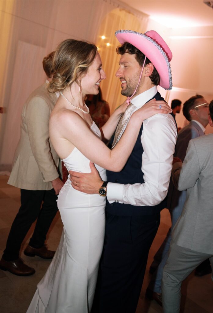 Romy and Jonathan dancing close together, Jonathan wearing a pink cowboy hat