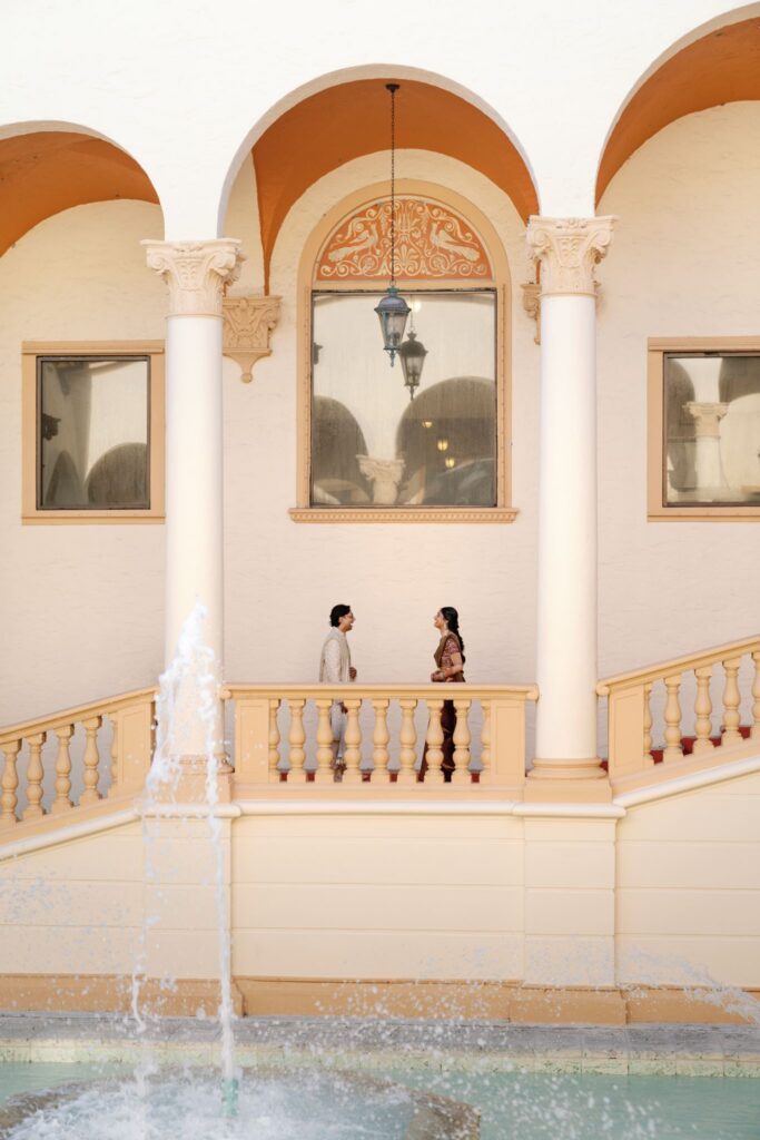 Couple standing on a balcony above a fountain at The Biltmore Hotel