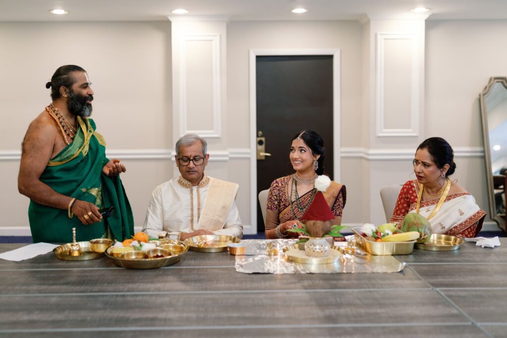 Priest and family seated at the table during the pre-ceremony rituals