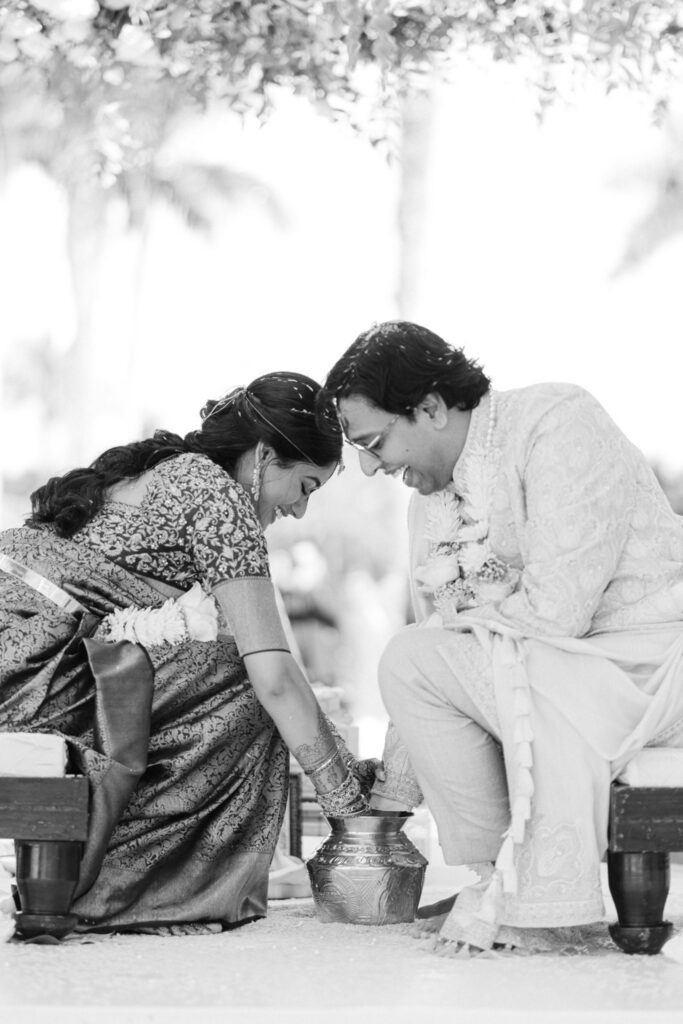 Black and white photo of a ceremony ritual with the couple bowing their heads together