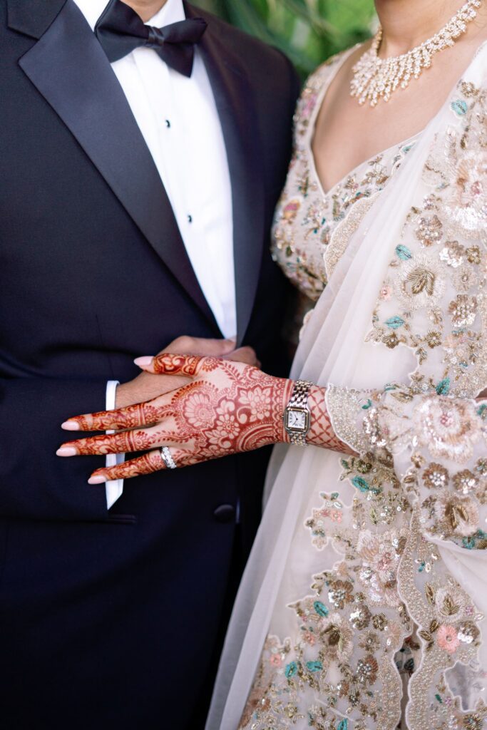 Detail of the groom's tuxedo and the bride's henna and embroidered ivory lehenga
