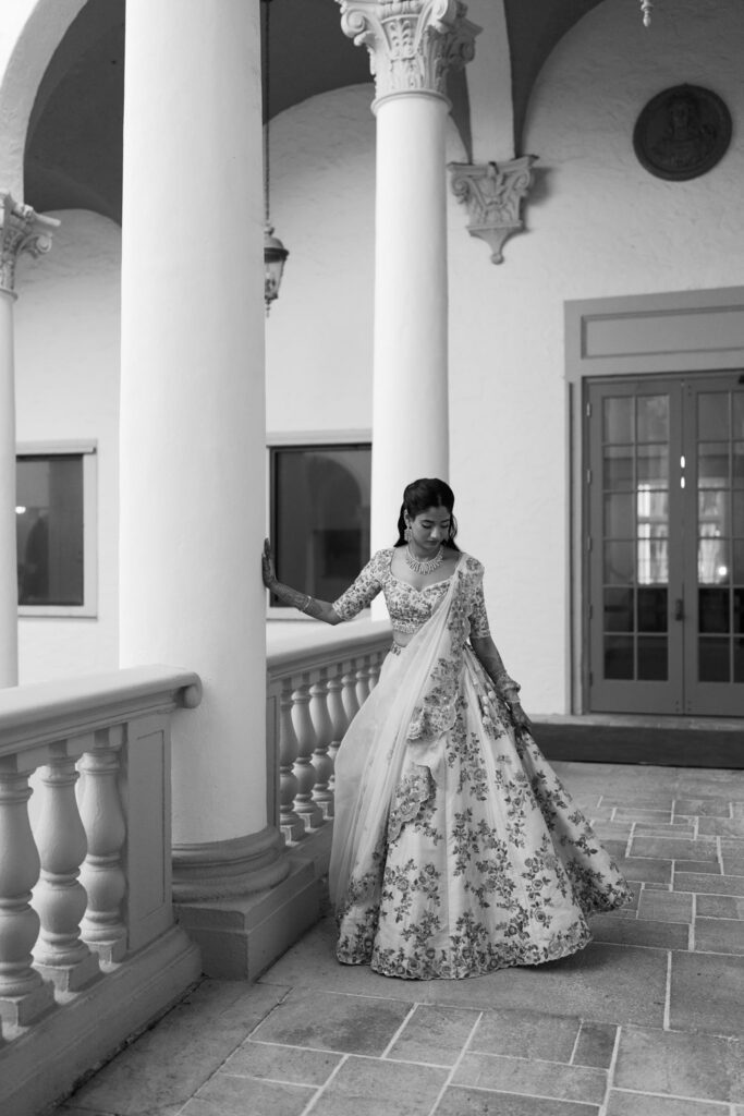 Black and white photo of Advaitaa twirling in her lehenga on a Biltmore balcony