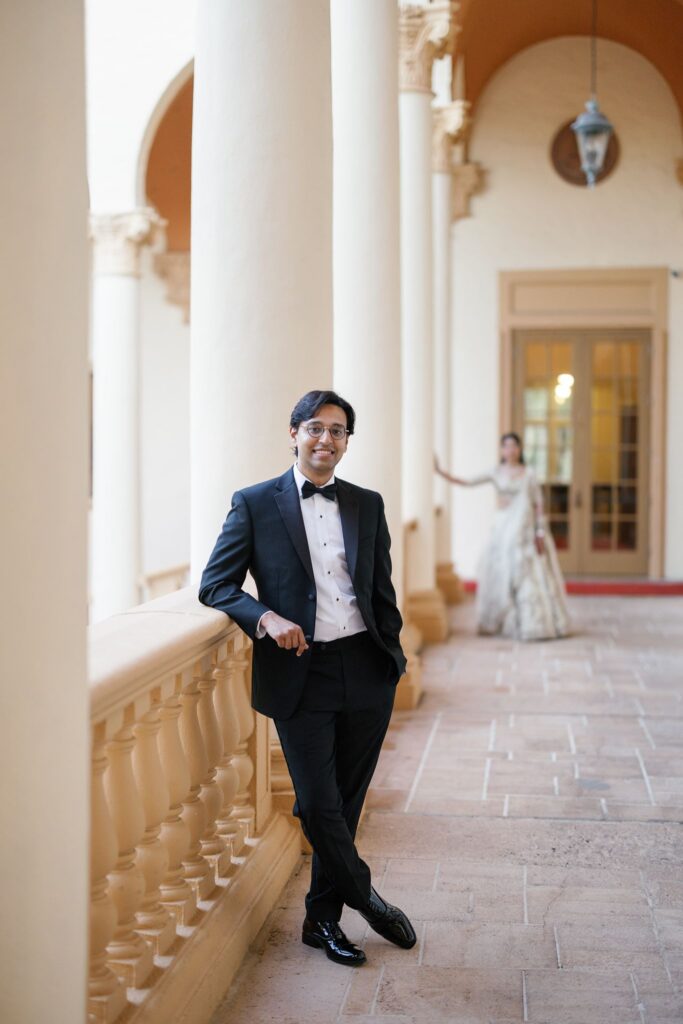 Tejus in a tuxedo leaning against a column on the arcade