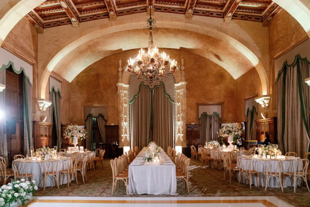 Reception ballroom set with round tables and a chandelier at The Biltmore Hotel