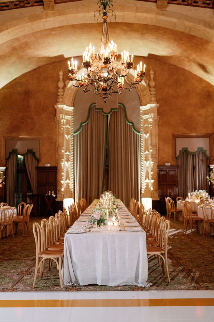 Long reception table beneath a chandelier in the Granada Ballroom