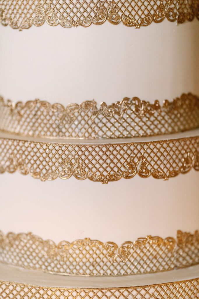 Close-up of the wedding cake's gold lace detail