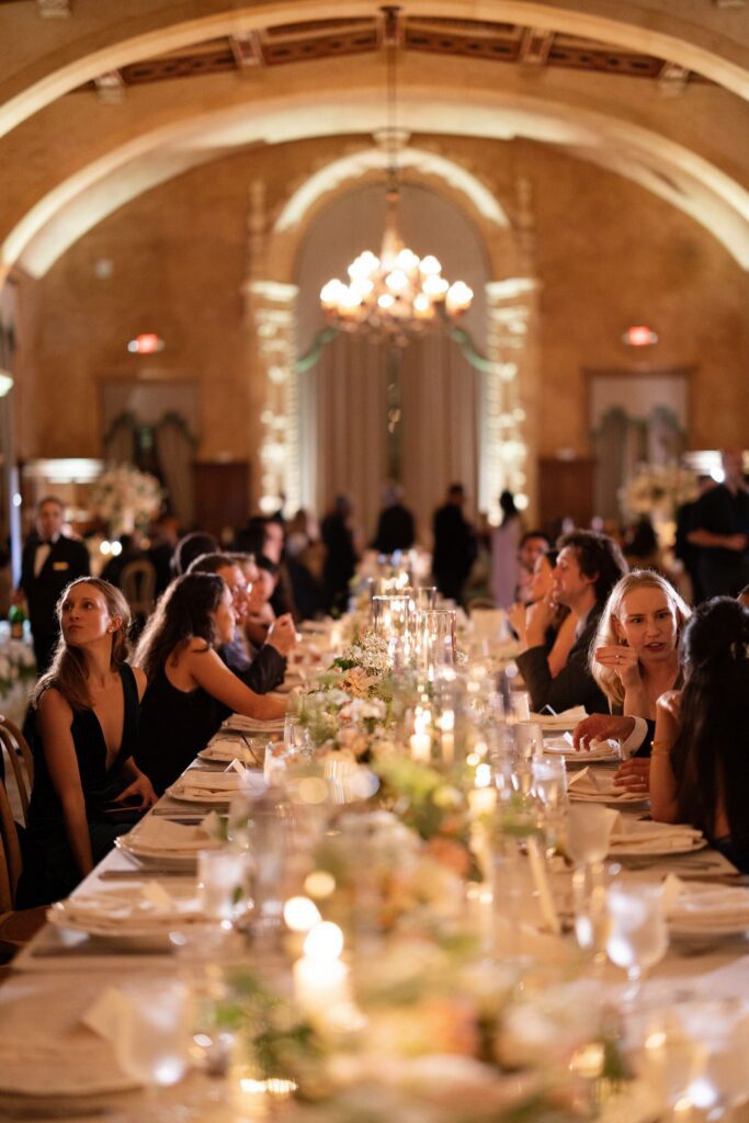 Guests seated at the long candlelit dinner table
