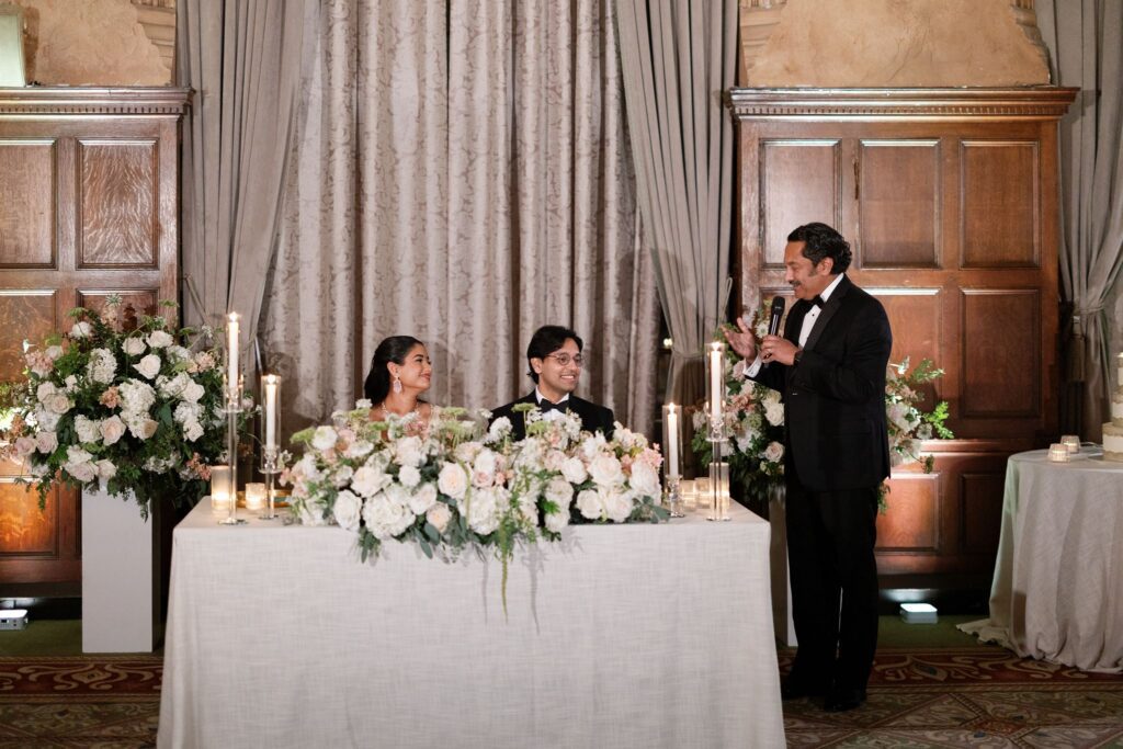 Groomsman giving a toast at the sweetheart table