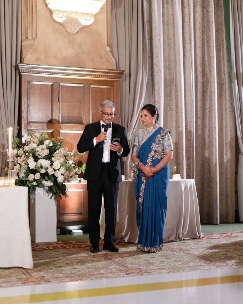 A man and woman giving a speech at the reception