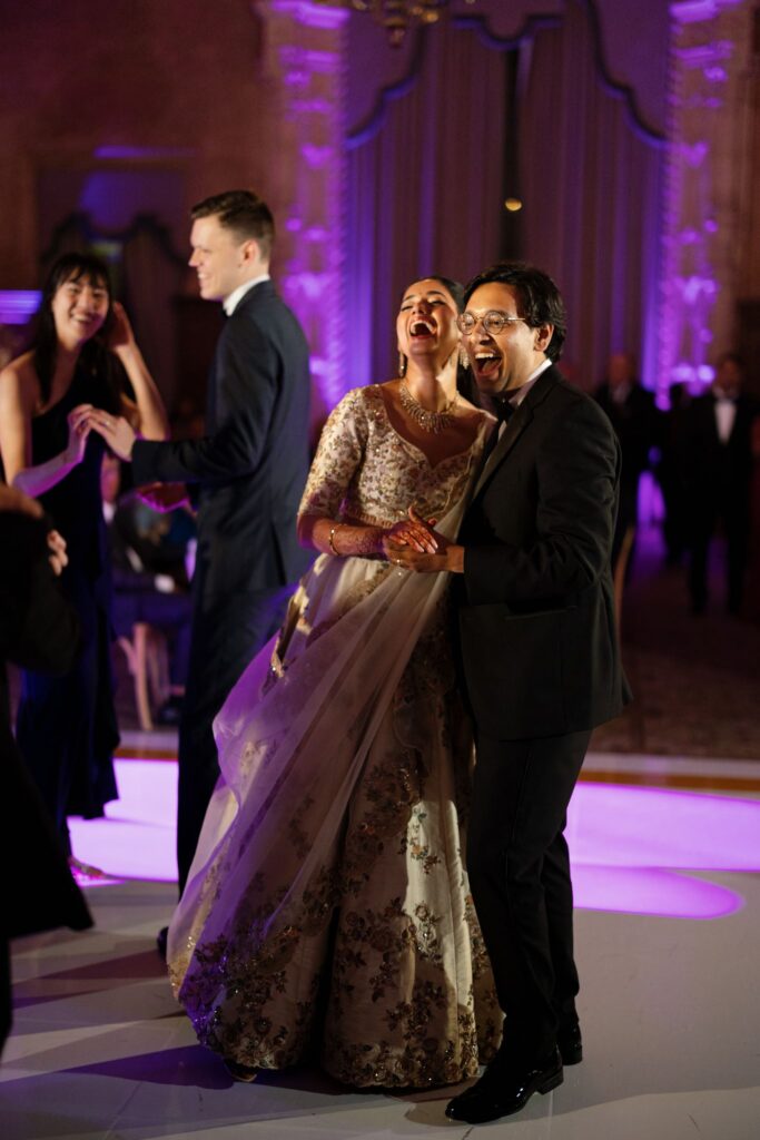 Advaitaa and Tejus laughing during their dance under purple lighting
