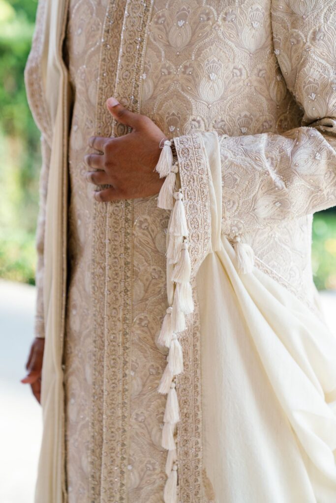 Detail of the embroidered ivory and gold sherwani and its tassels