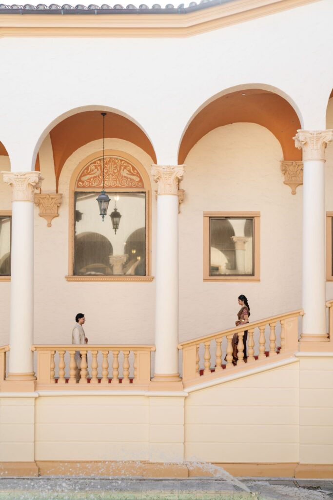 Architectural shot of Bride making her way to her Groom for their First Look in Biltmore staircase
