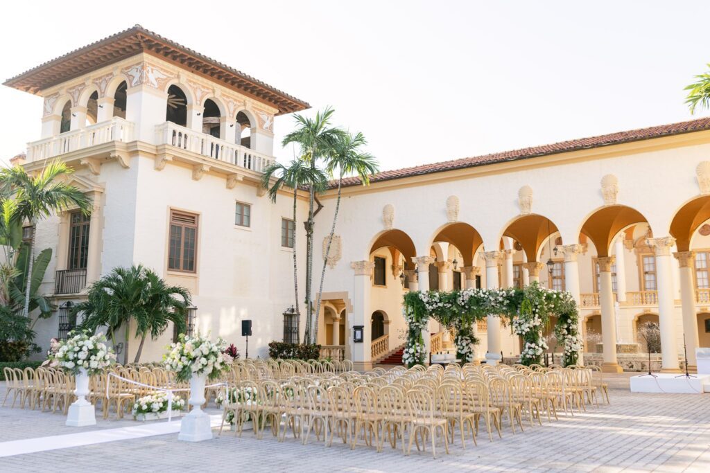 Hindu ceremony at The Biltmore Hotel courtyard with a white aisle and arched loggia