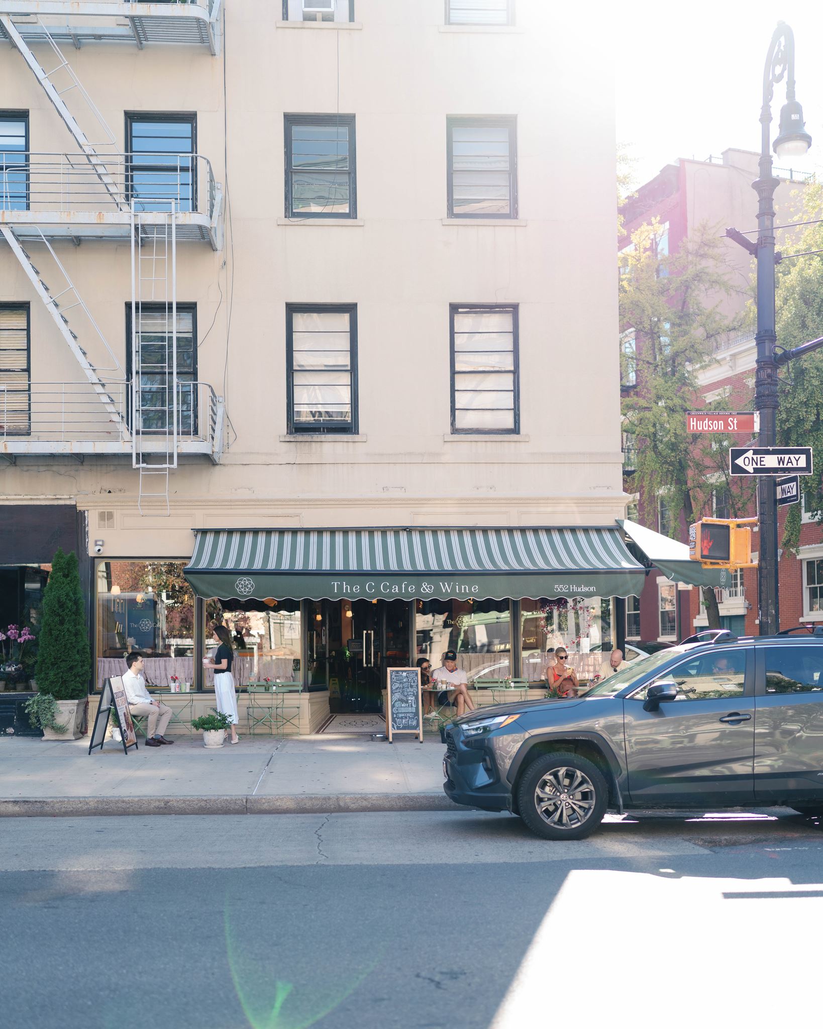 Haley and Jeremy sharing coffee at a sidewalk café table in the West Village