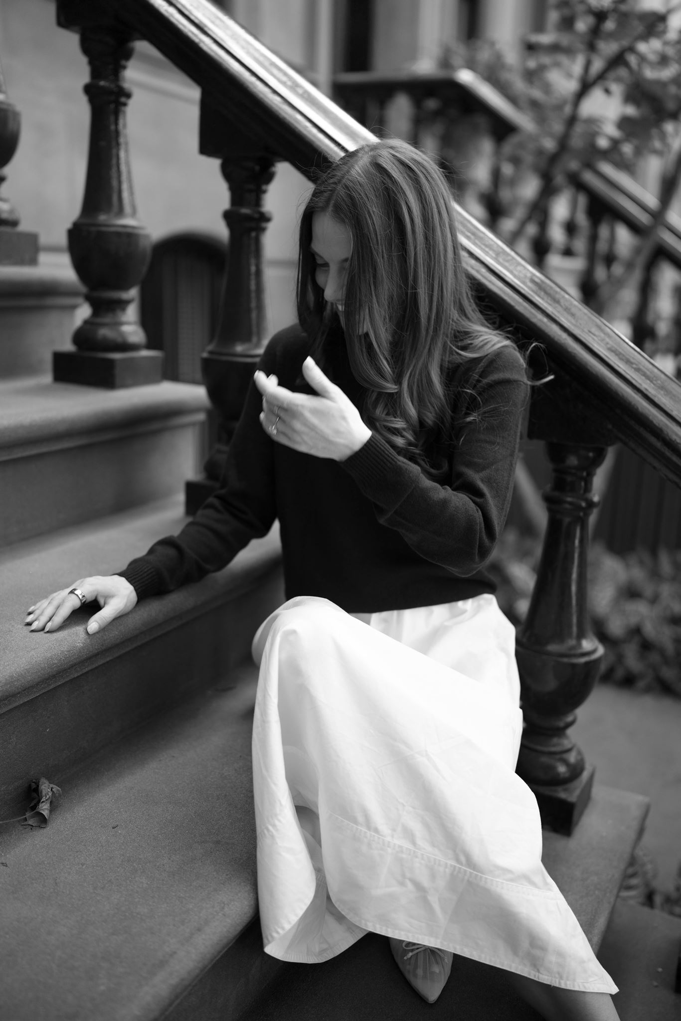 Black and white photo of Haley laughing on Brown step in West Village, New York City