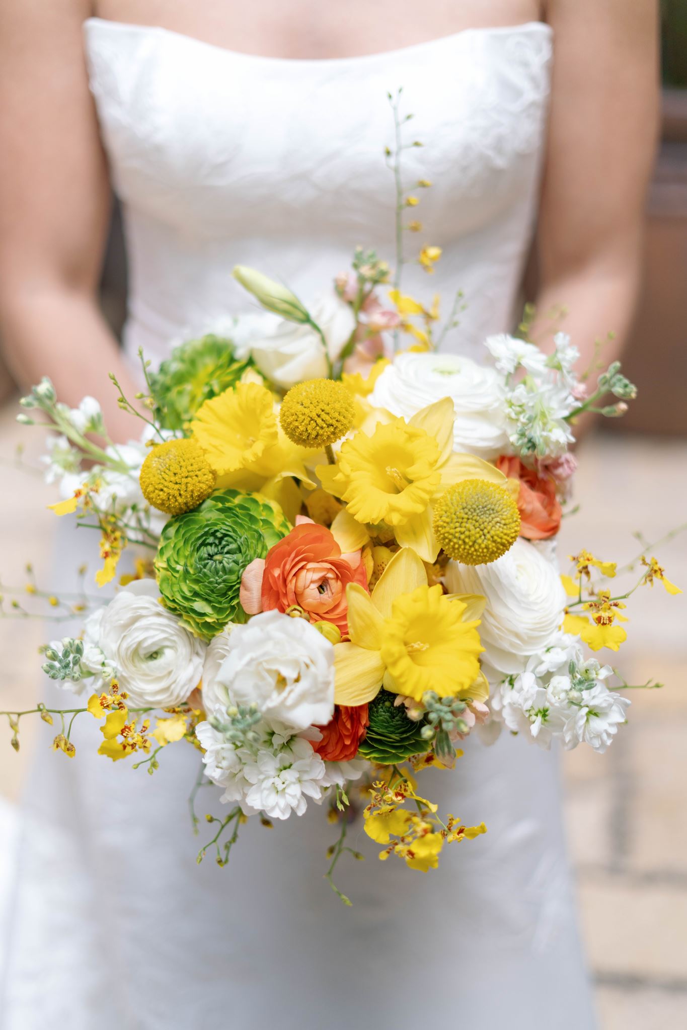 Bride's bouquet including a colorful selection of yellow, green, white and orange flowers